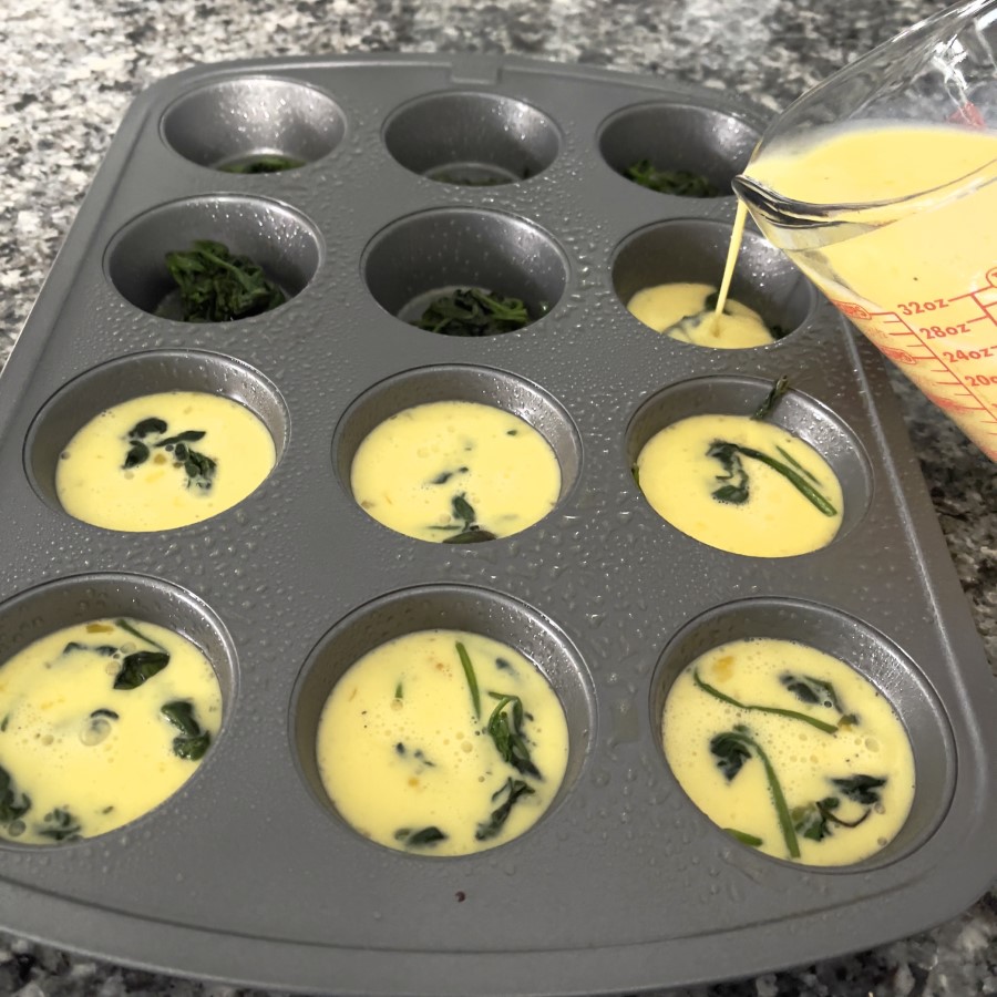 Pour egg mixture over the cooked spinach for the egg bites.