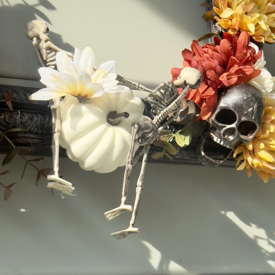 Skeleton antics climbing a pumpkin.