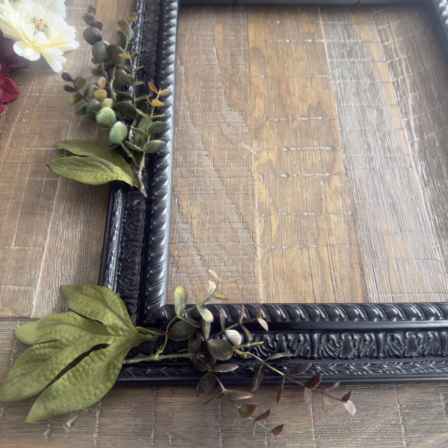 Green leaves and faux stems hot glued to a frame.