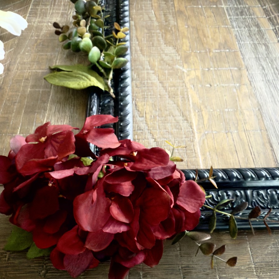 Burgundy hydrangeas are hot glued to a frame to create a fall wreath.