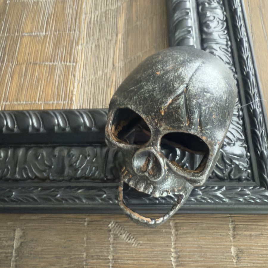 Metal skull bottle opener used as an embellishment for a spooky Halloween frame wreath.